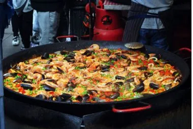 Delicious paella with mollusks in big frying pan